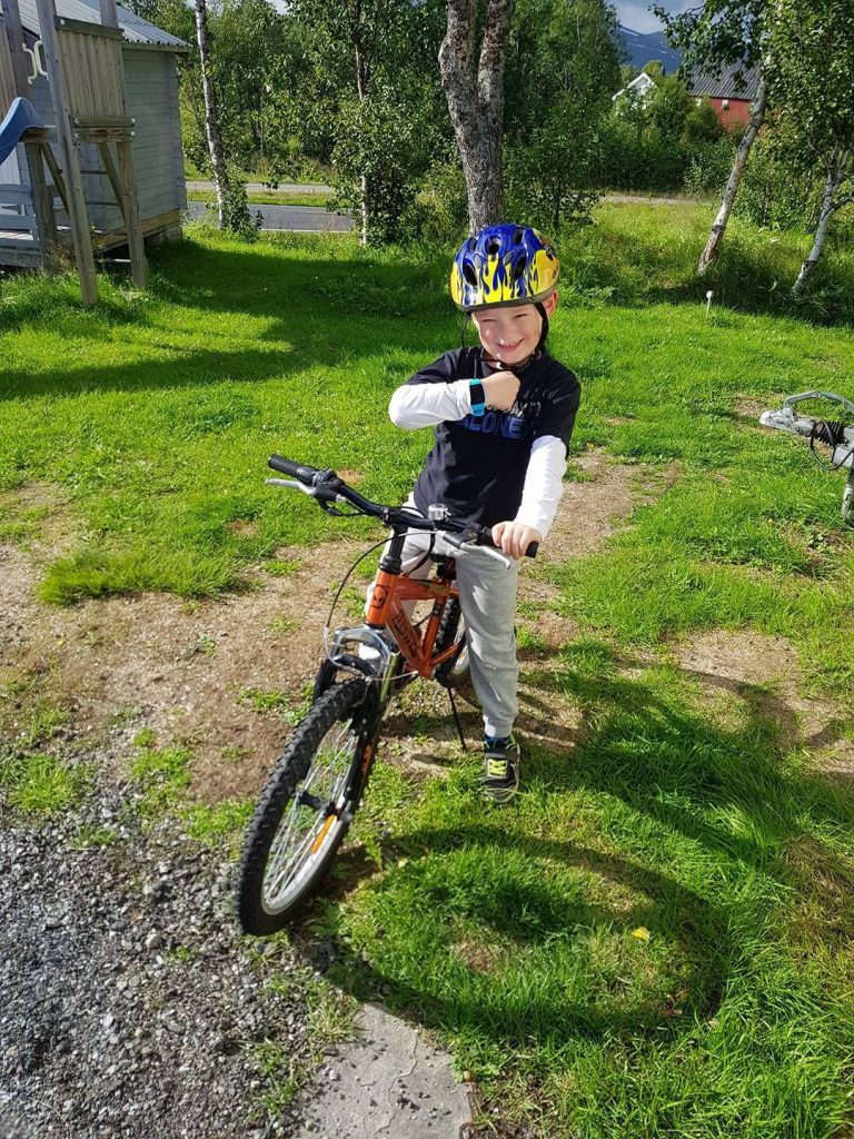 Boy on a bike with a smartwatch for kids